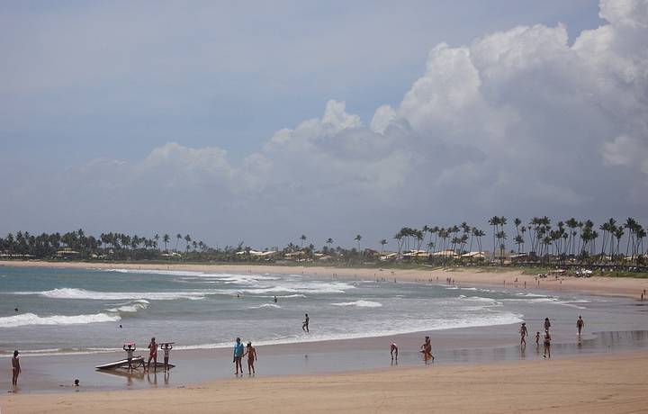 Praia que d nome  vila  extensa salpicada de coqueiros