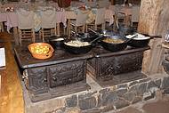 Feijão-tropeiro e arroz-de-carreteiro são preparados no fogão à lenha