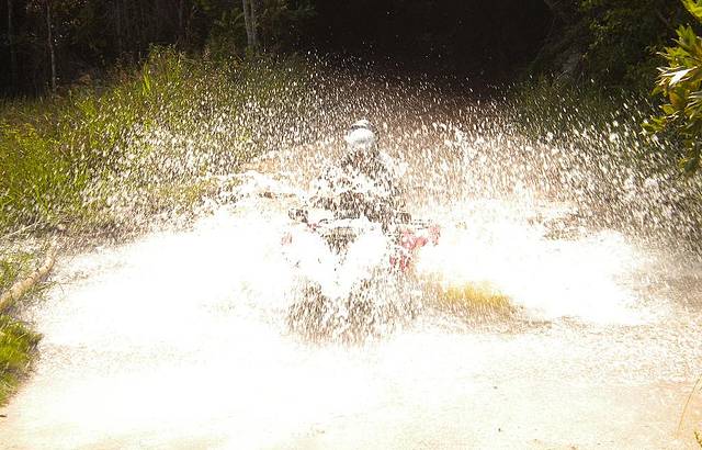 Passando com o quadriciclo em um riacho formado pela chuva