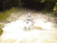 Passando com o quadriciclo em um riacho formado pela chuva