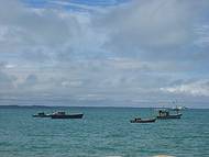 Mar azul e barcos de pescadores na praia de Coroa Vermelha...